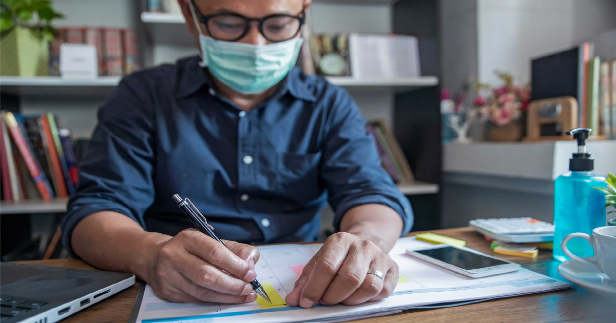 A man in mask planning his schedule